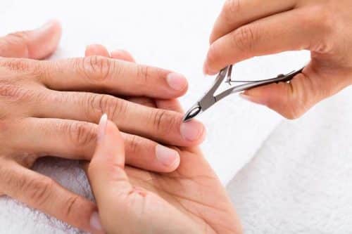 Close-up Of A Manicurist Cutting Off The Cuticle From The man's Fingers