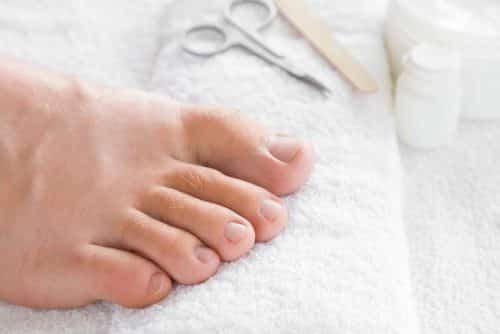 Cares about men's feet nails. Pedicure, manicure beauty salon concept. Scissors and nail file on the white towel.