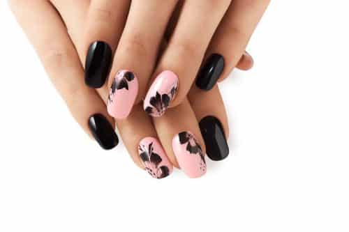 Abstract floral pattern on pink nails black.